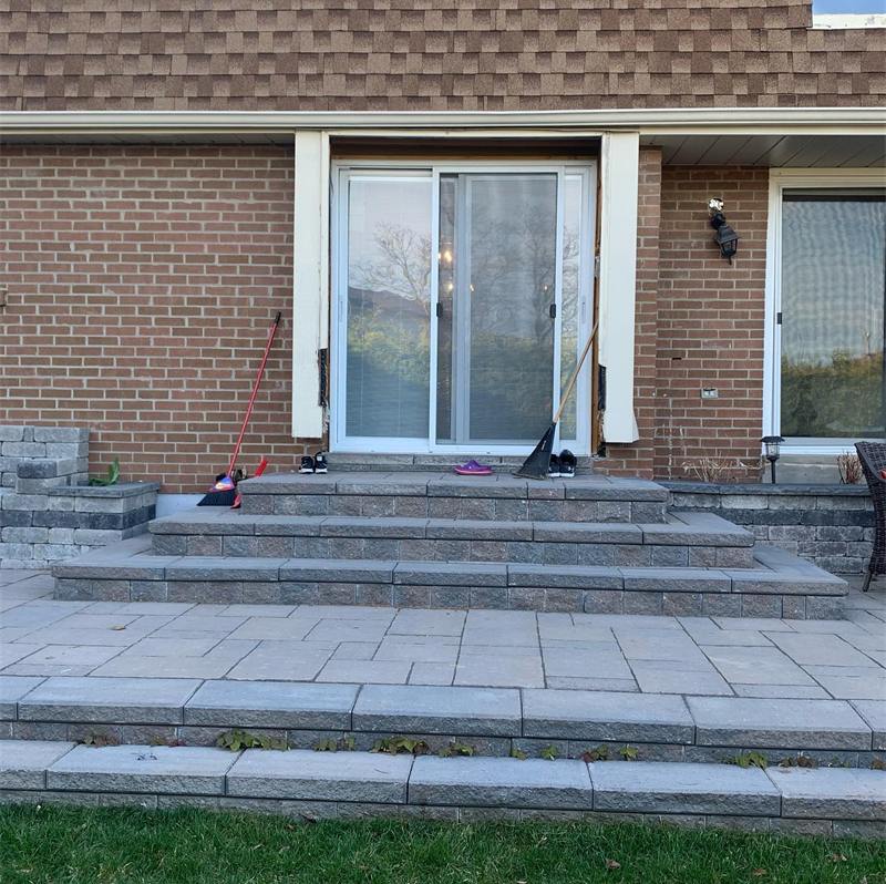 Interlock patio and wide steps at the back of a brick home