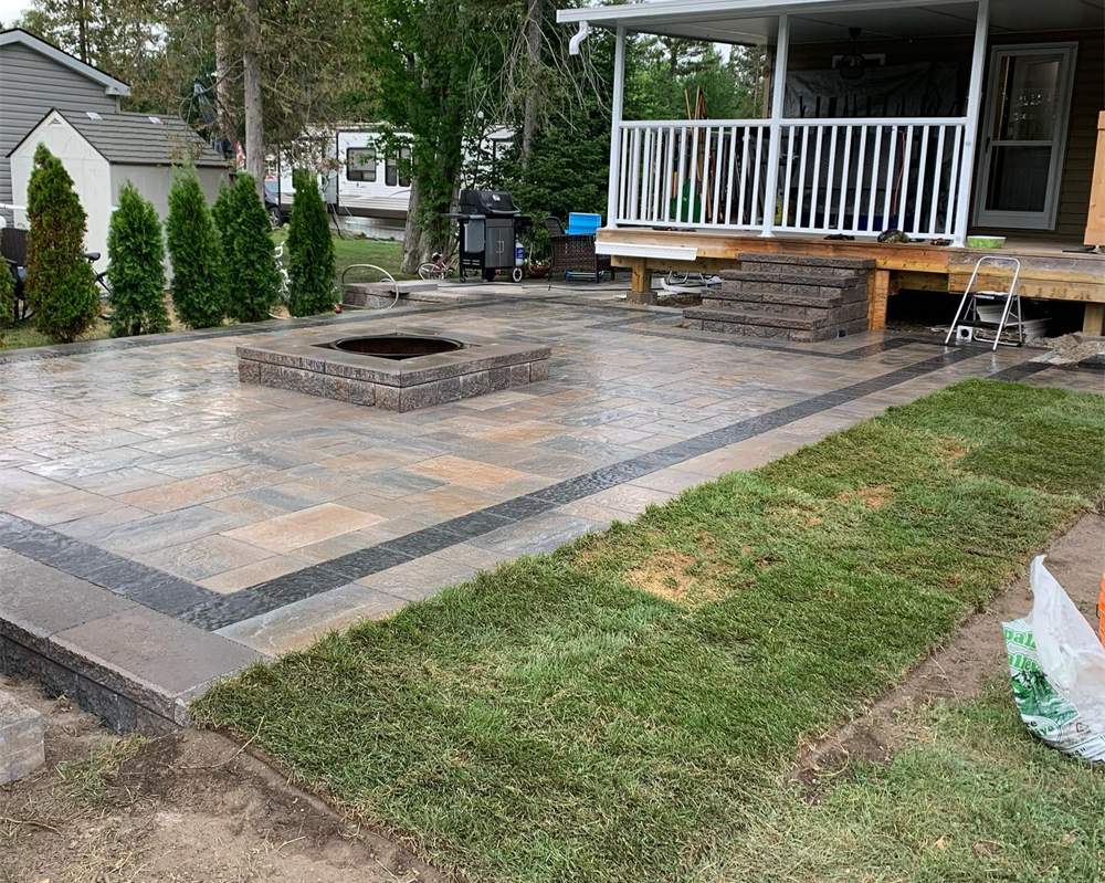 New interlock patio with a built-in fire pit, fresh sod and a covered deck