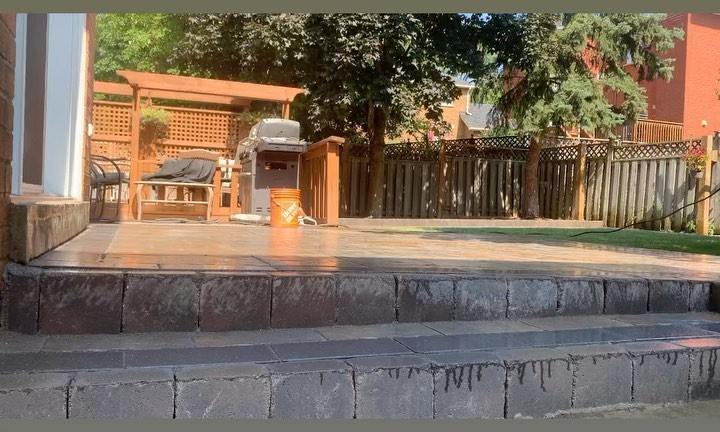 Interlock patio steps leading to a backyard with a grill